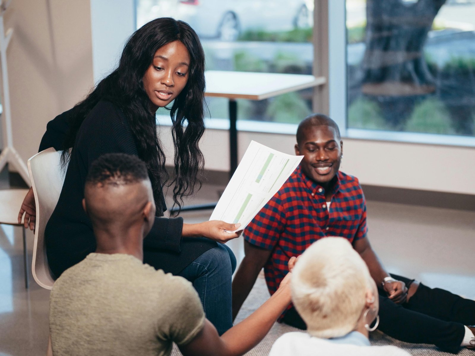 A diverse group of colleagues engaged in a collaborative office discussion with documents.